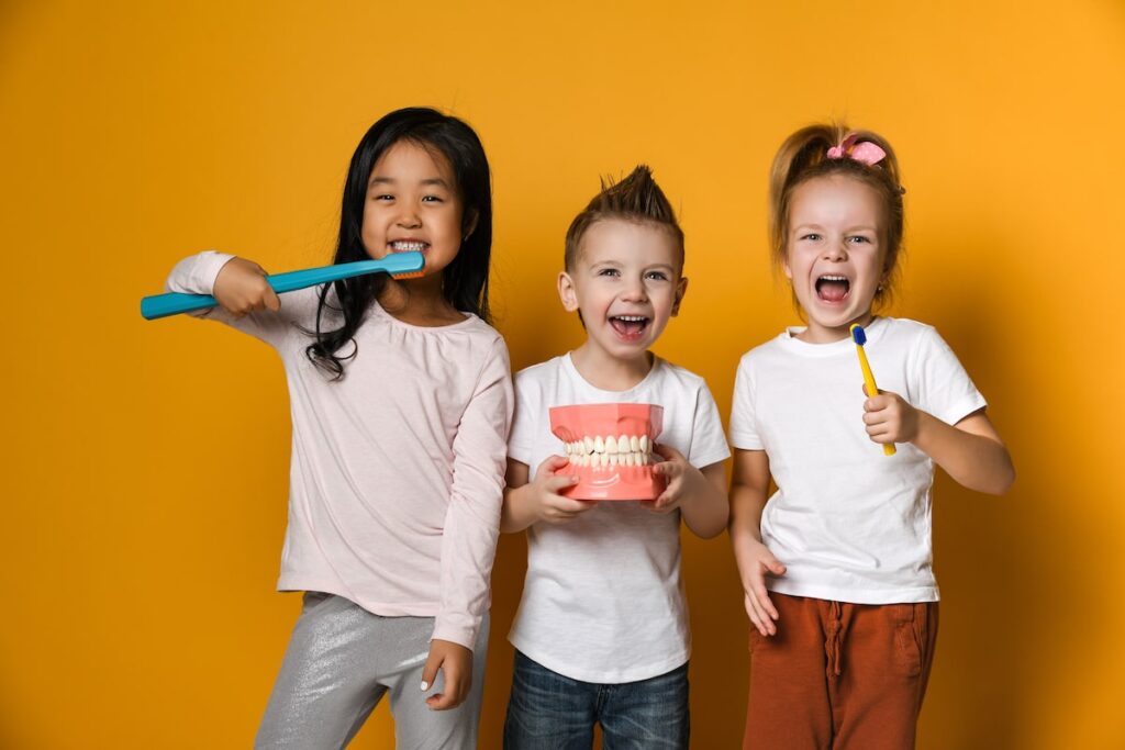 Kids smiling and brushing teeth